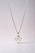 Silver necklace with a clover-shaped pendant on a light gray background