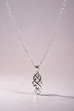 Silver necklace with a Celtic knot pendant on a light pink background