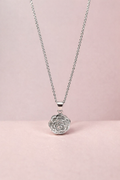 Silver necklace with a rose-shaped pendant on a pink background