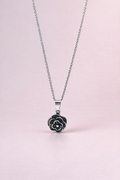 Necklace with a floral pendant on a light pink background