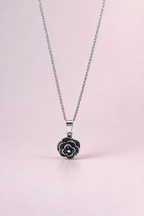 Necklace with a floral pendant on a light pink background